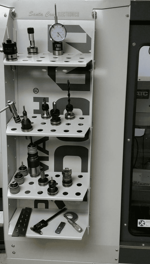 Metal cabinet with shelves displaying various machining tools and parts in a manufacturing setting.