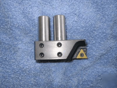 Triangular metal tool with cylindrical protrusions and three circular holes.