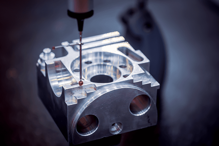 Metal object with holes being machined using a drill bit or end mill.