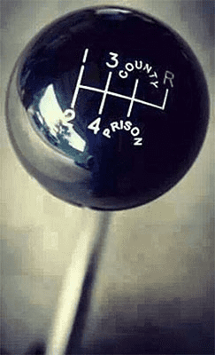 A black gearshift knob with white lettering and lines on a gray background, featuring numbers 1-4 and an "R" symbol.