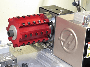 Red cylindrical machine part with gear design and silver metal base.
