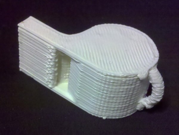 3D printed musical instrument with long, narrow body and curved end.