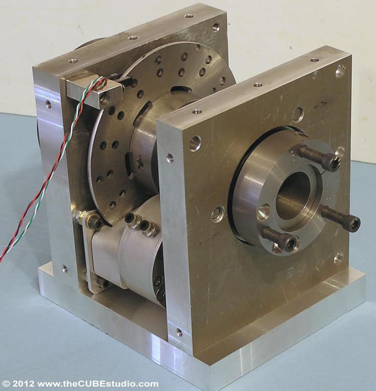 Metal component with wires and small holes, secured by bolts.