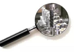 Magnifying glass with various cutting tools inside.