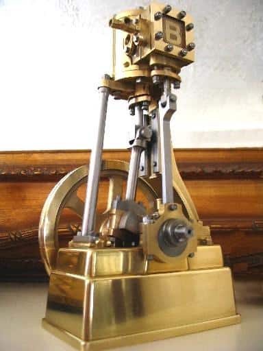 Antique brass steam engine on display in a museum, showcasing intricate details.
