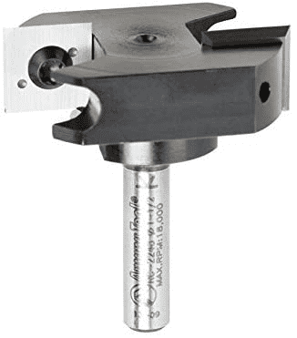 A black-and-white metal component with cylindrical base and flat top, featuring a hole and small protrusion.