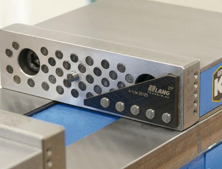 Silver metal device with holes and an angled black attachment.