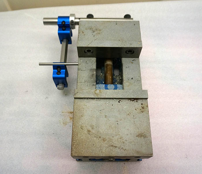 Metalworking vise with blue clamp.