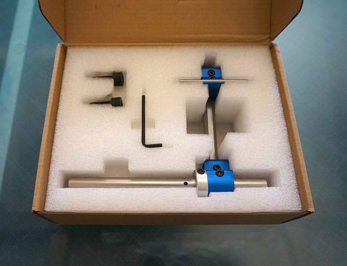 Cardboard box with tool set and blue/white vise/clamp inside.