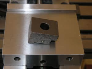 Silver metal object with a central hole, possibly a machined part.