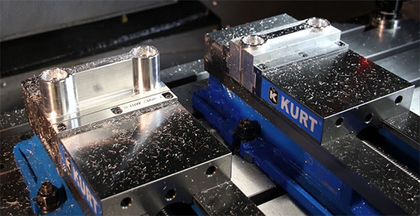 Kurt Manufacturing part flip vise jaw on a machine table.