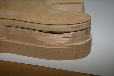 Close-up of a light-colored wooden object with a chipped edge.