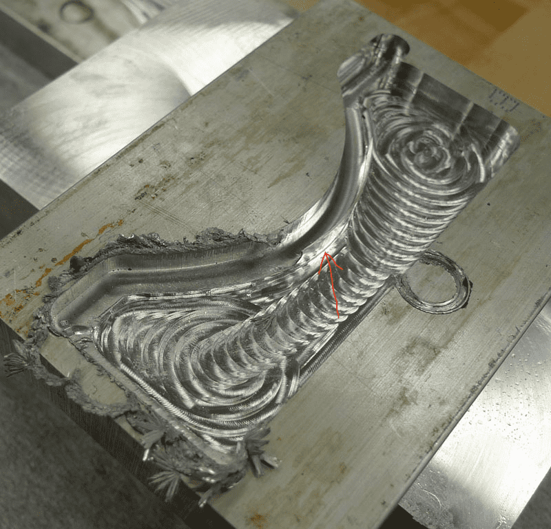 Metal part with intricate curved and spiral designs, demonstrating CNC machining capabilities.