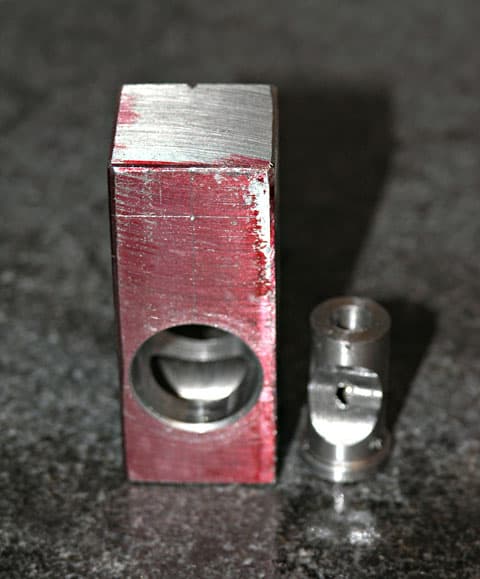 Aluminum metal tool with red anodized finish and 0.25 inch circular hole.