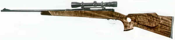 Rifle with wooden stock and metal barrel, photographed from left side view.