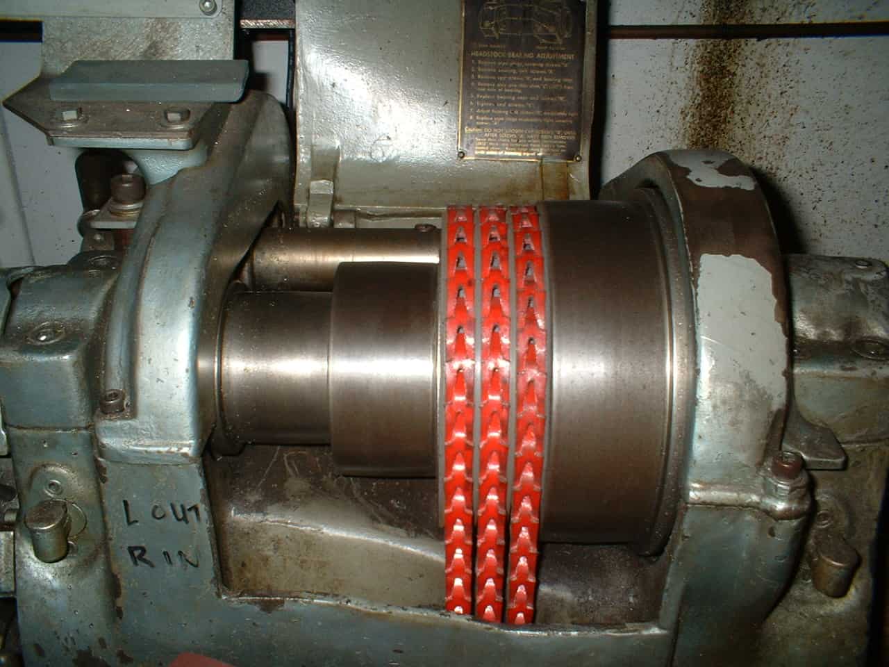 Large metal cylinder with red chain wrapped around it in an industrial setting.