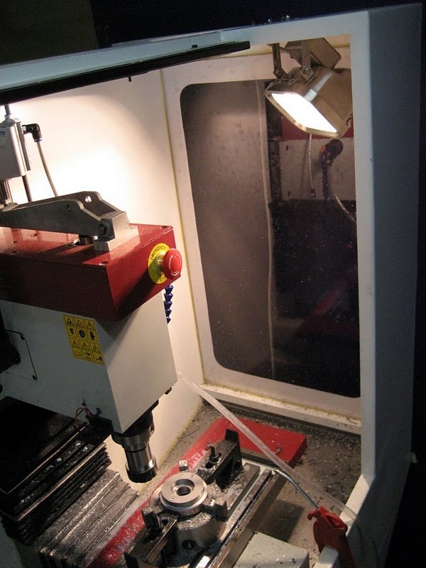 Industrial machine with red and white components and glass window.