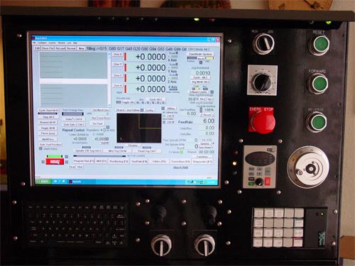 A control panel with a computer screen displaying settings and controls, buttons, dials, and knobs.