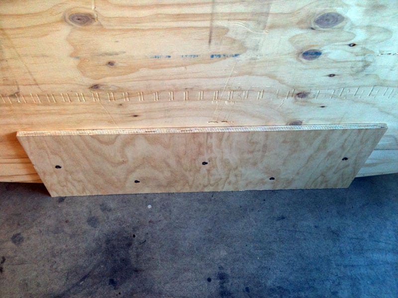 Close-up photograph of plywood with rectangular cutout on top of another sheet.