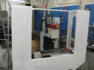 Large white machine with red control panel in industrial setting.