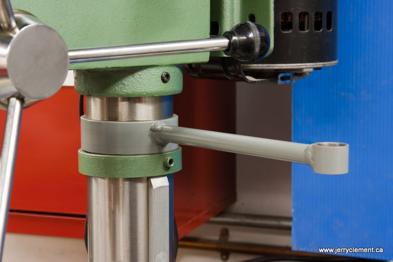 Close-up of a drill press/milling machine collet chuck with green metal body and silver shaft/knob.