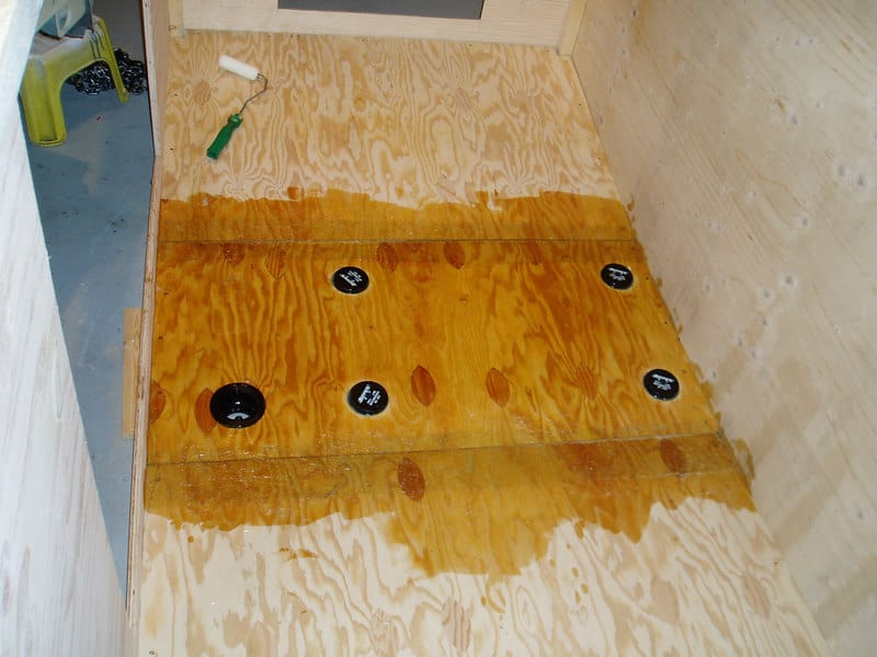 A wooden box with plywood walls and floor, sealed with a yellowish-brown substance.