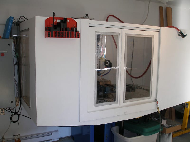 Large CNC machine with glass windows and cables, showcasing its design and capabilities.