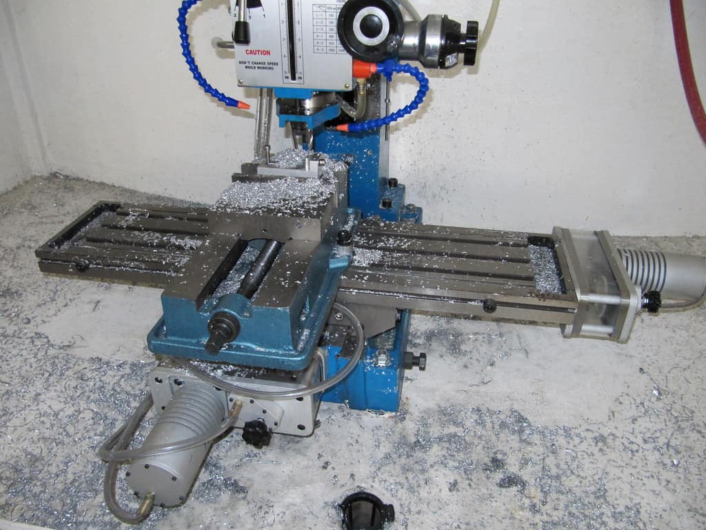 Metalworking machine in a workshop setting with metal shavings.