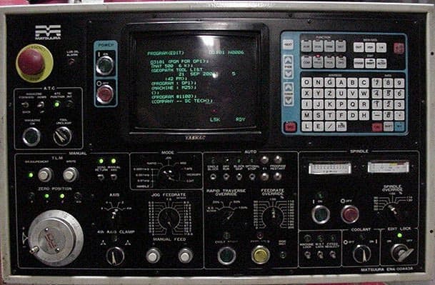 Black control panel with buttons, knobs, and screen displaying green text.