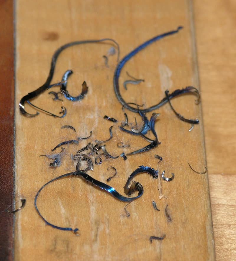 Metal shavings on a wooden surface.