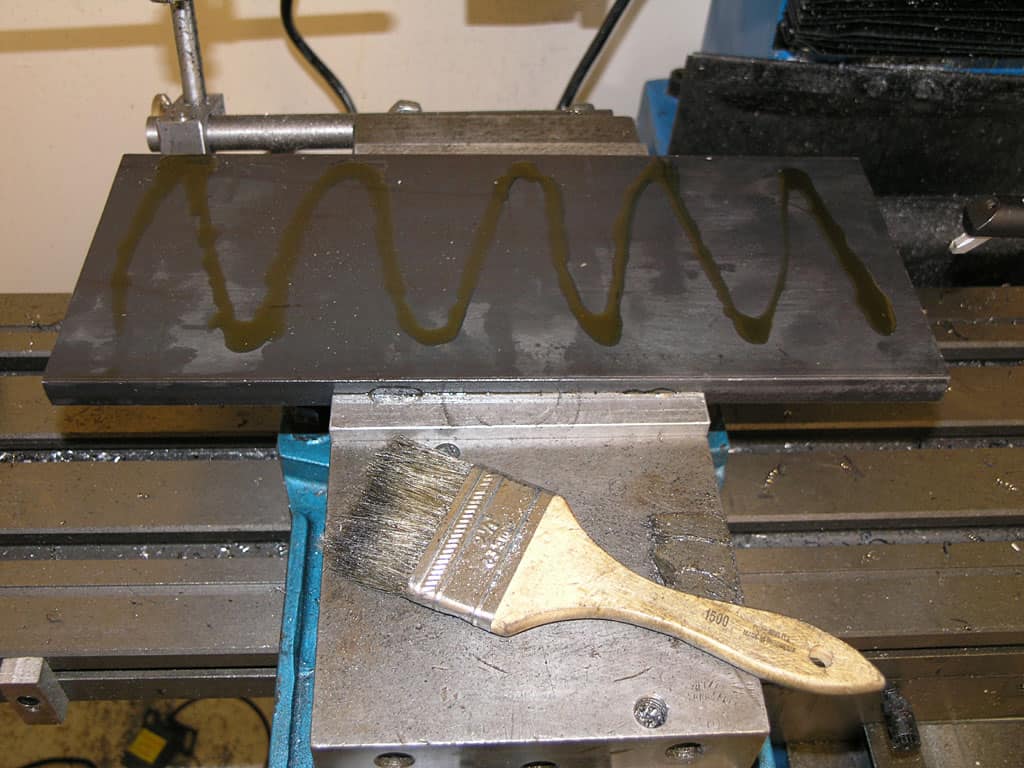 Metalworking vise with paintbrush on top.