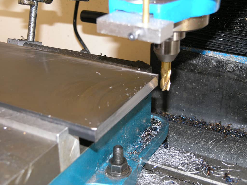 Milling machine cutting tool in operation, surrounded by metallic shavings.