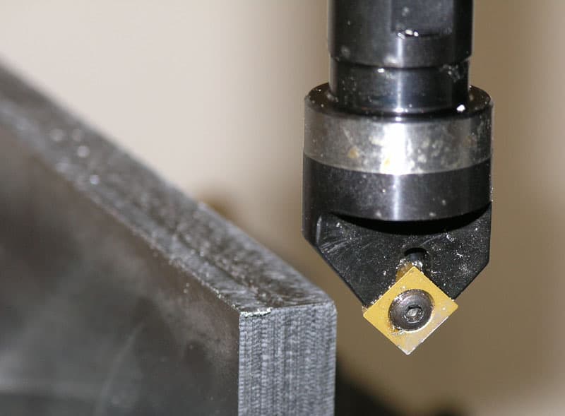 Milling cutter with diamond-shaped cutting tool on metal object.