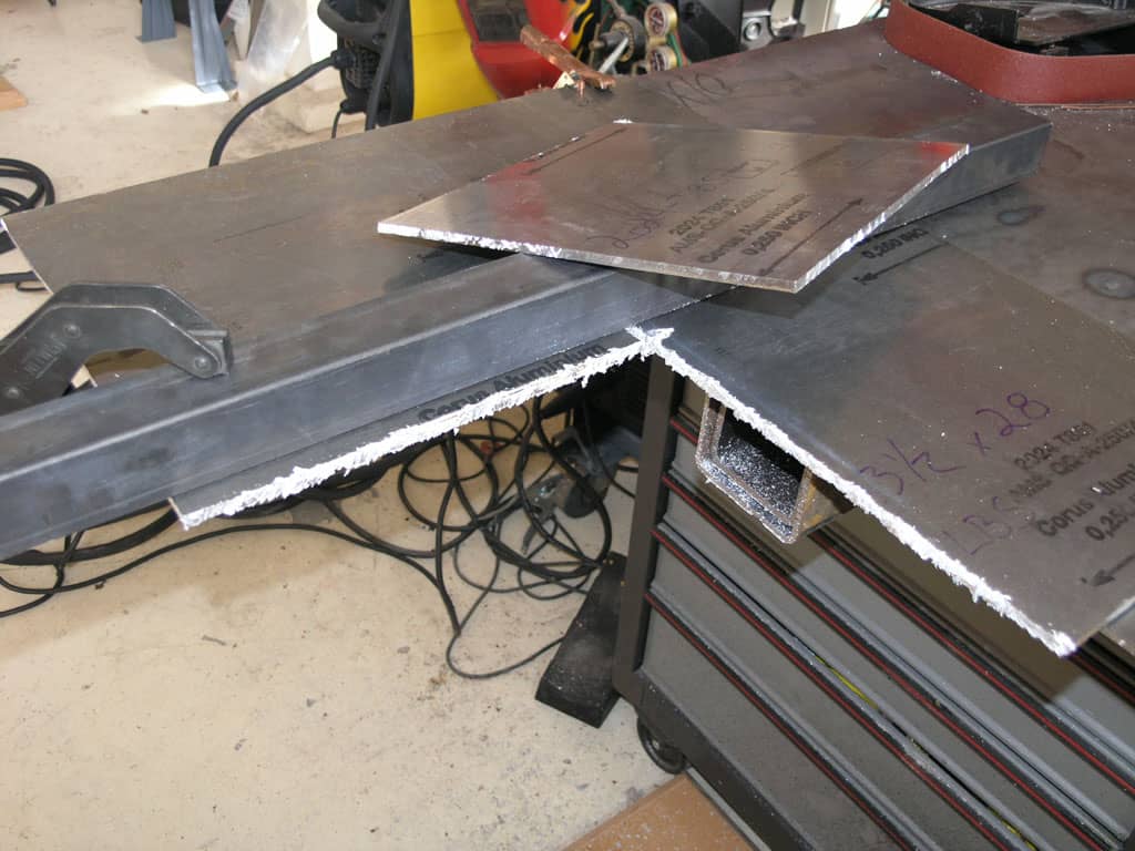 Metal cutting machine in industrial setting, showcasing its capabilities for precision metal processing with various attachments and a built-in vise.