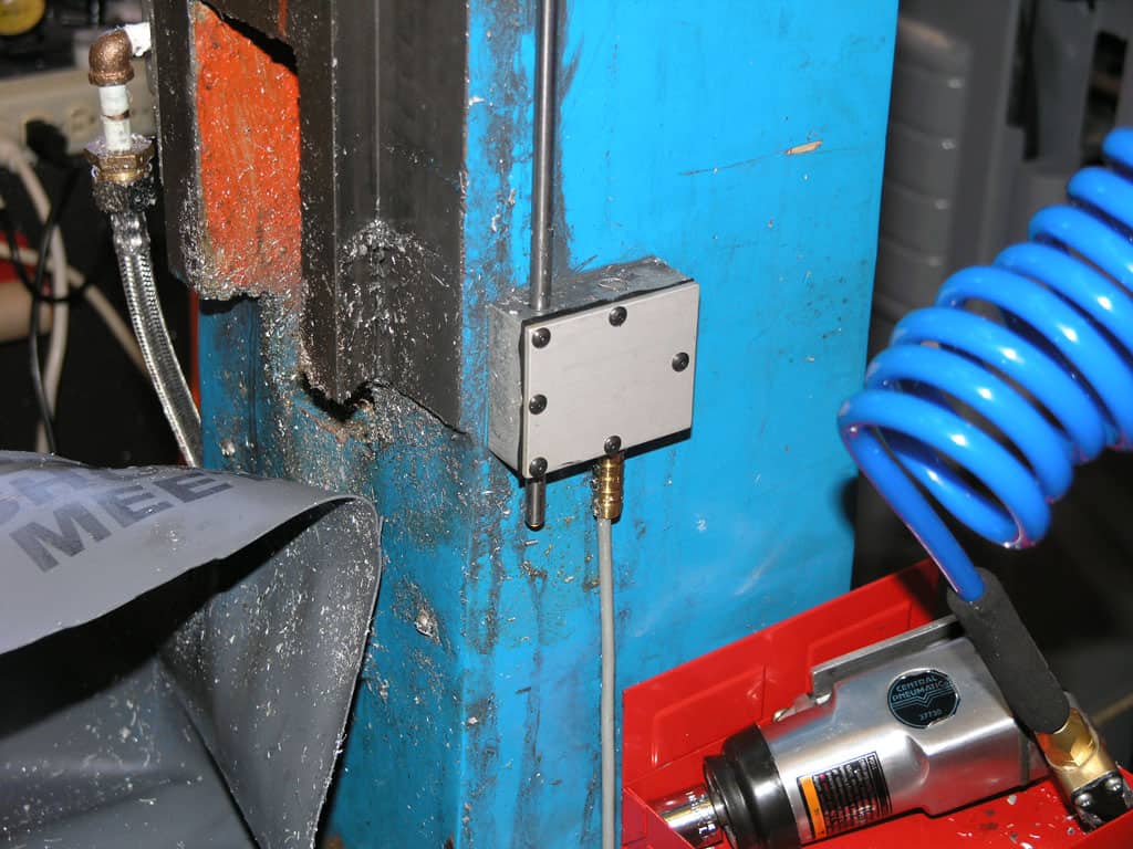 Industrial workshop setting with blue walls, white electrical box, and machinery.