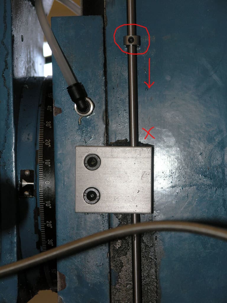 Metal door with blue paint, attached components, ruler, rod, bolts, and two small central holes.