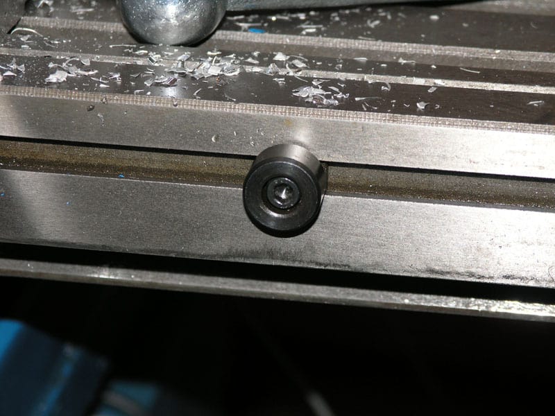 Metal surface with a small black circular object attached.