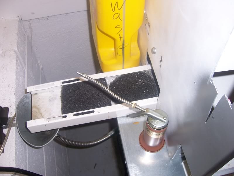 Metalworking setup with various tools and equipment on a light gray background.