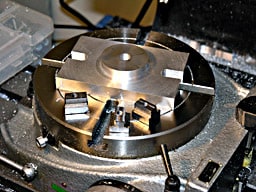 Metal component with circular shape and four protruding points.