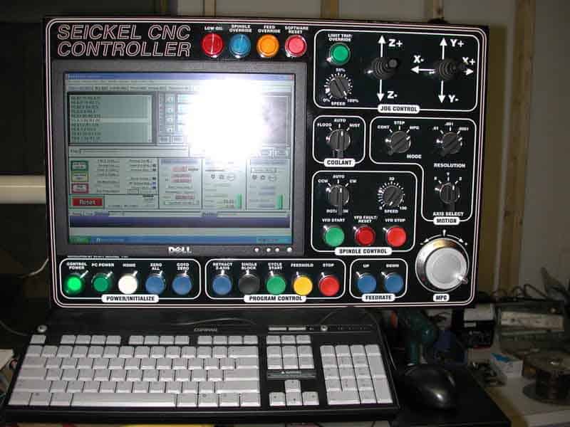 Seickel CNC mill control panel with large screen, buttons, dials, keyboard, mouse, and indicator lights.