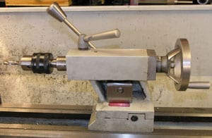 Metal tailstock with spindle and handle.