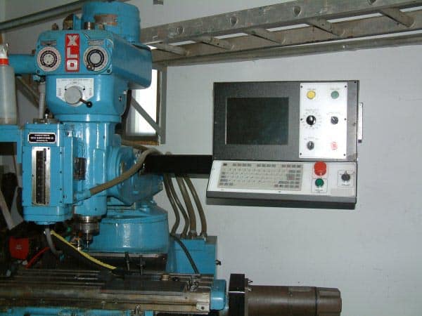 A blue XLO mill with control panel and drill press.