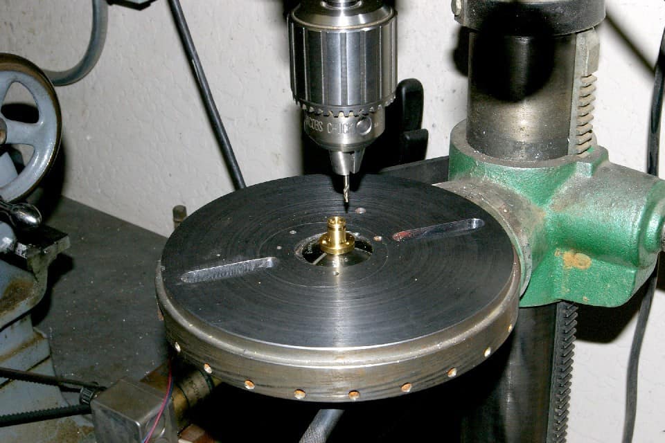 A metal lathe with a drill press attachment on a green machine base.