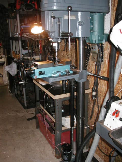 Well-organized workshop with drill press, lathe, milling machine, and welding equipment.