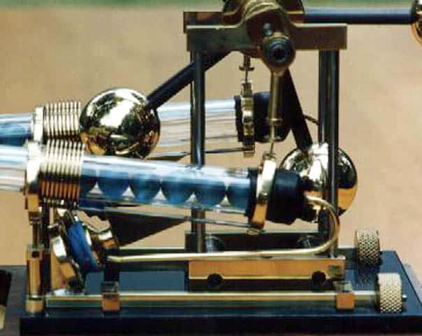 Metal device with cylindrical component and attached spherical elements.
