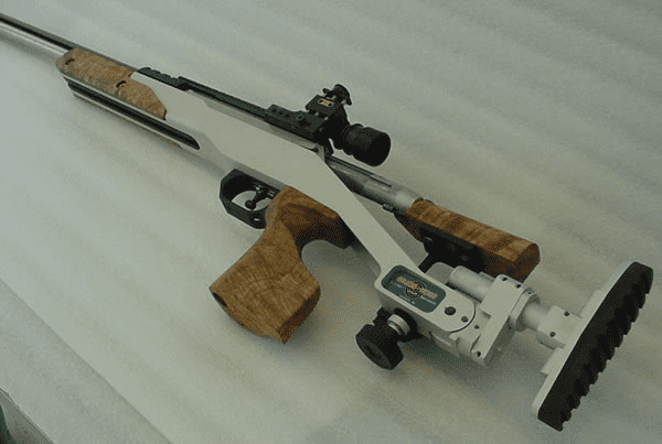 Rifle with silver body and wooden grip on a white background.