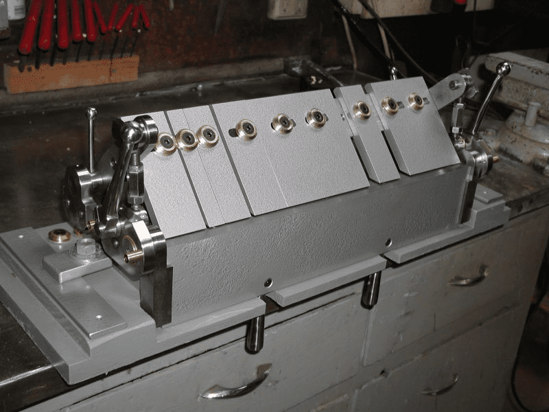 Large metal machine with flat base and vertical posts.