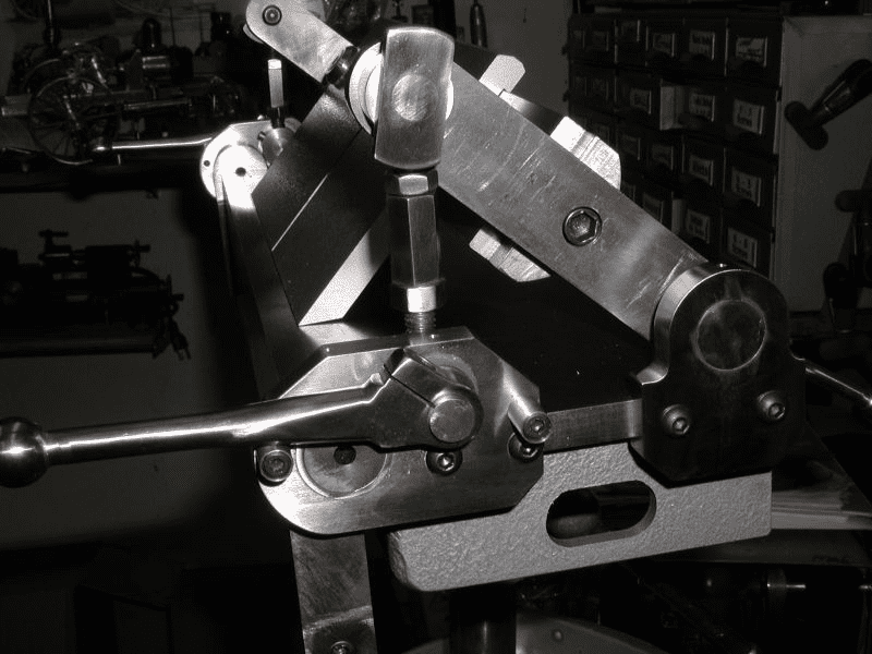 Large metal machine with multiple moving parts and levers, suggesting manufacturing or machining processes.