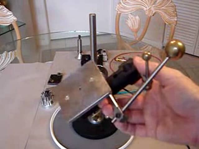 Metal device on table with objects surrounding it.