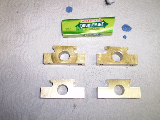 Brass objects, rectangular pieces with circular holes, Wrigley's gum.